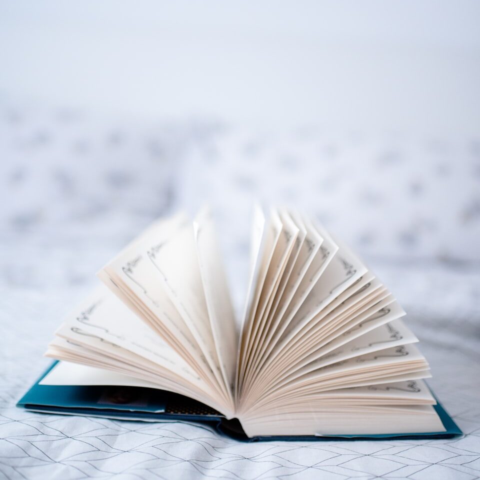opened book on white textile